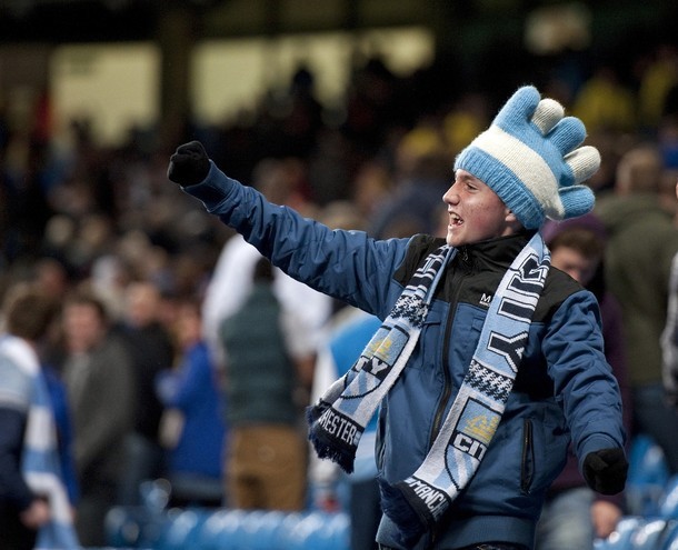 Một CĐV Man City ăn mừng chiến thắng ấn tượng trên khán đài với chiếc mũ len rất đặc biệt